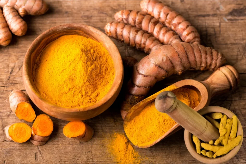 Fresh turmeric root and ground turmeric powder used in healthy cooking and wellness recipes